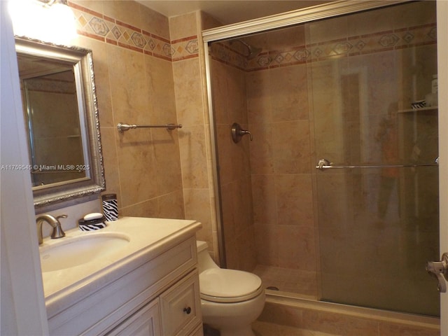 bathroom with toilet, vanity, and a stall shower