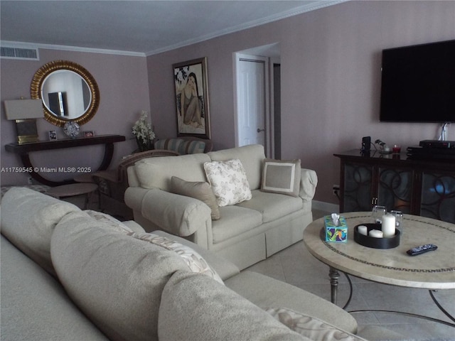 living area with visible vents, tile patterned flooring, baseboards, and ornamental molding
