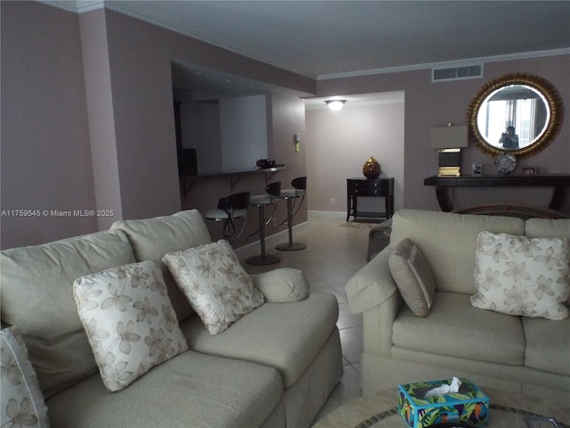 living room featuring baseboards, ornamental molding, and visible vents