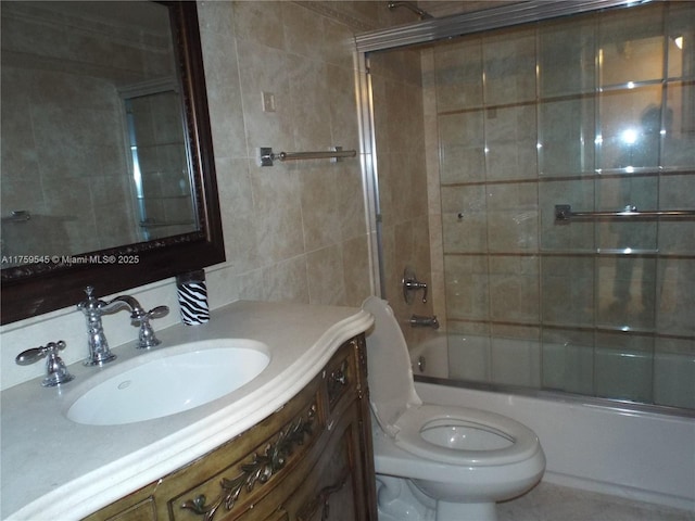 full bathroom featuring shower / bath combination with glass door, tile walls, toilet, and vanity