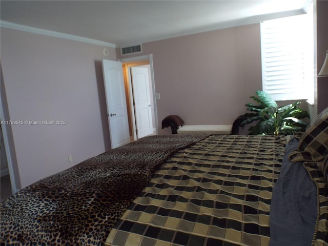bedroom featuring visible vents and crown molding