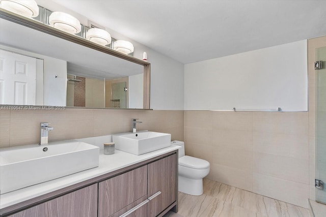 full bath with double vanity, a shower stall, tile walls, and a sink