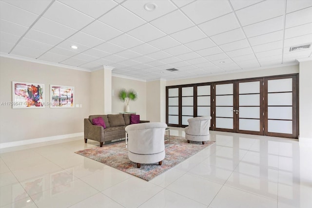 living area featuring baseboards, visible vents, crown molding, and tile patterned floors