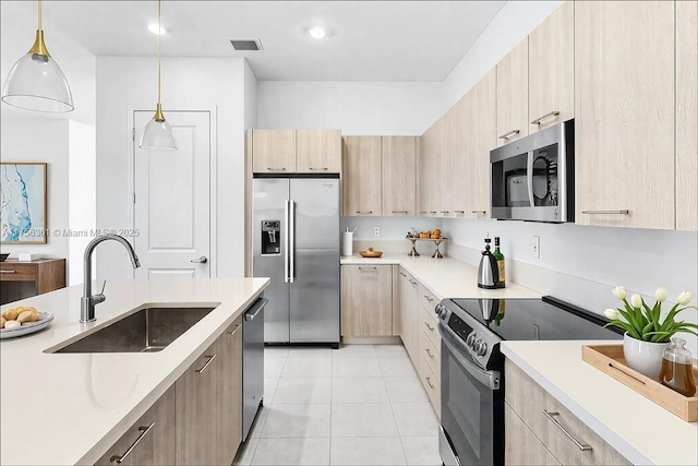 kitchen with visible vents, light brown cabinetry, a sink, appliances with stainless steel finishes, and light countertops