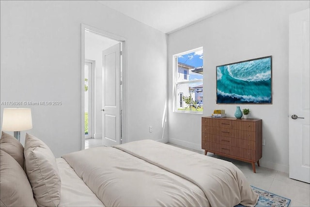 bedroom with light tile patterned floors and baseboards