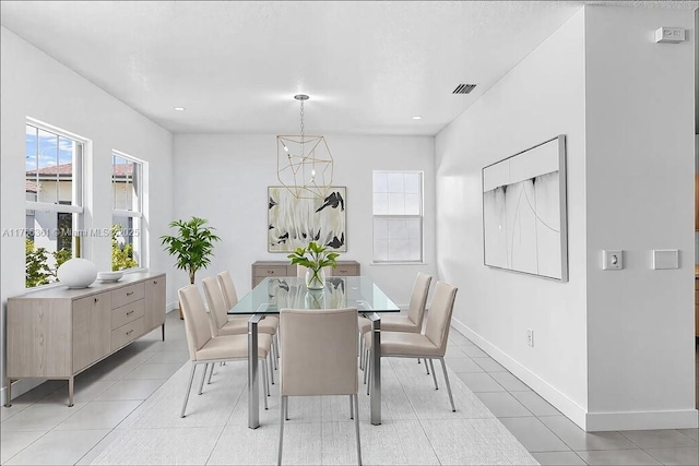 dining room featuring light tile patterned floors, visible vents, and baseboards