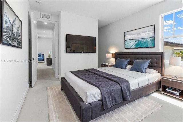 bedroom with visible vents, baseboards, and finished concrete flooring