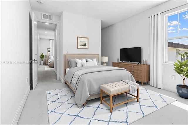 bedroom featuring visible vents, baseboards, and concrete flooring