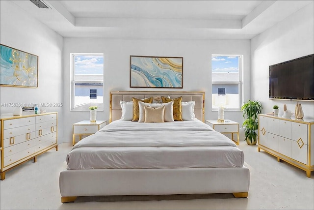 bedroom featuring visible vents, multiple windows, and a tray ceiling