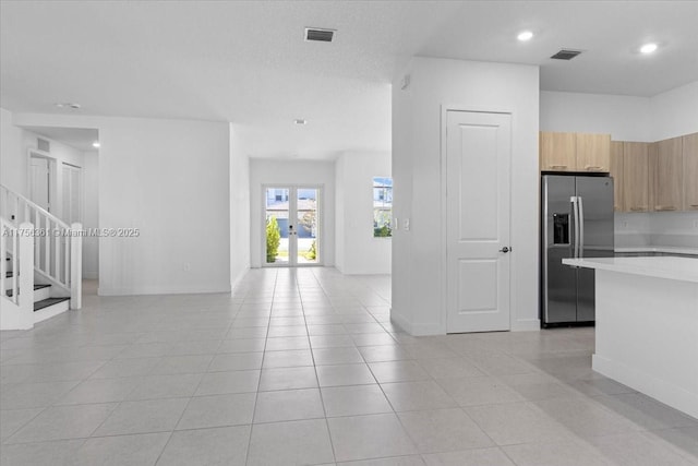 kitchen featuring visible vents, stainless steel fridge, french doors, and light countertops