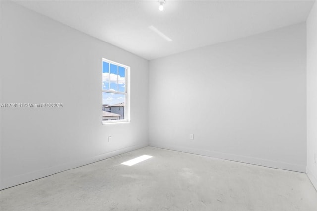 empty room featuring baseboards and concrete flooring