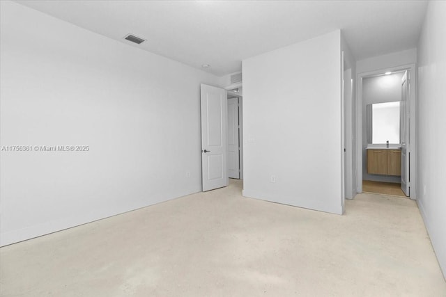 unfurnished bedroom with visible vents, concrete floors, and connected bathroom