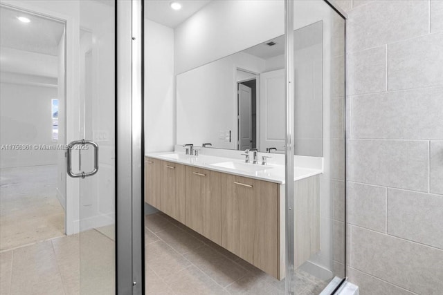 full bath featuring tile patterned flooring, a shower stall, double vanity, and a sink