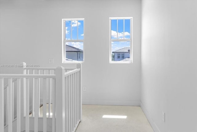 hall featuring an upstairs landing and baseboards