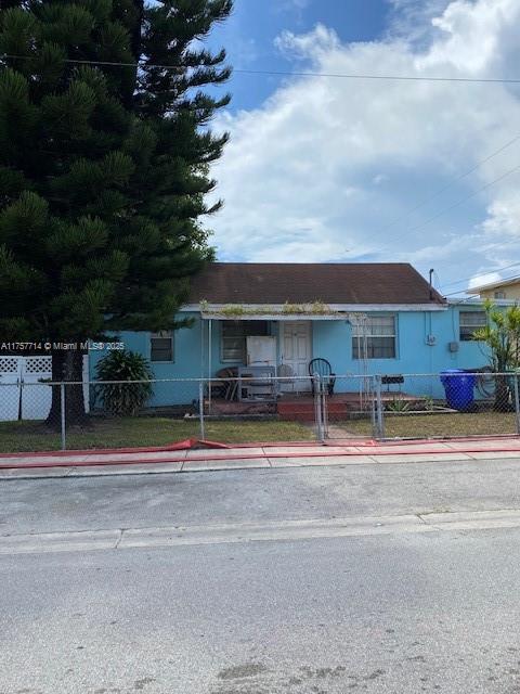 view of front of house with a fenced front yard and a gate