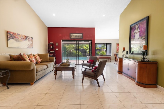 living room featuring light tile patterned flooring, baseboards, and a towering ceiling