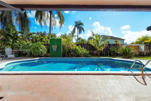 view of swimming pool featuring a patio, fence, and a fenced in pool