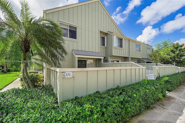 view of property exterior with a fenced front yard and board and batten siding