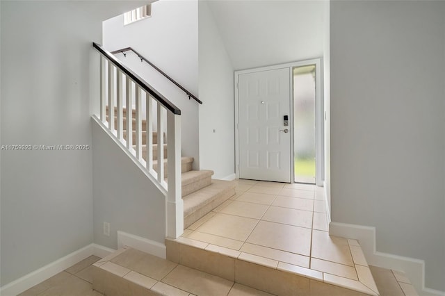 tiled foyer entrance with stairway and baseboards