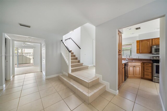 spare room with light tile patterned floors, stairway, and baseboards