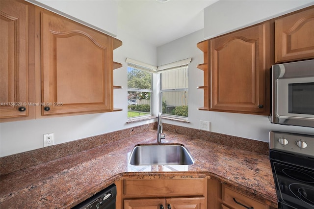 kitchen featuring stainless steel microwave, dark stone counters, electric range, and a sink