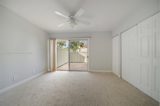 unfurnished bedroom featuring multiple closets, access to exterior, carpet flooring, baseboards, and ceiling fan