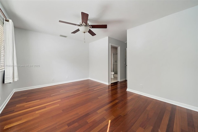 spare room with ceiling fan, wood finished floors, visible vents, and baseboards