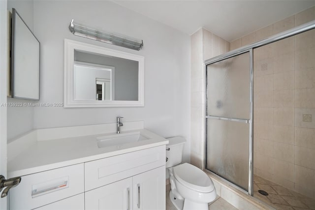 full bathroom featuring vanity, a shower stall, and toilet