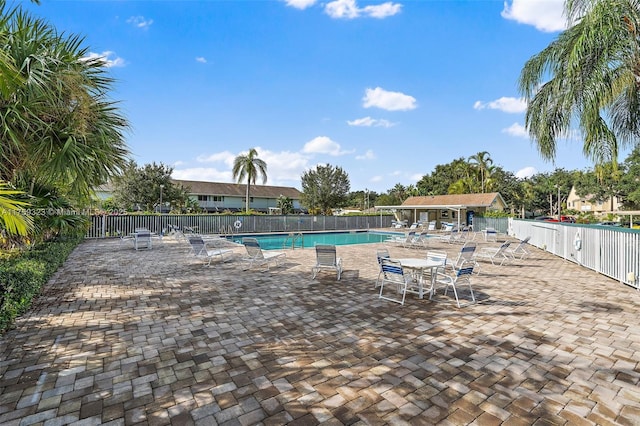 community pool featuring a patio and fence