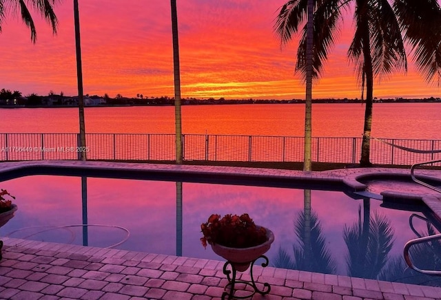 view of swimming pool featuring a fenced in pool, a water view, and fence