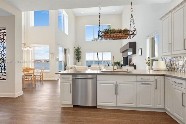 kitchen featuring open floor plan, white cabinets, dark wood-type flooring, and stainless steel dishwasher