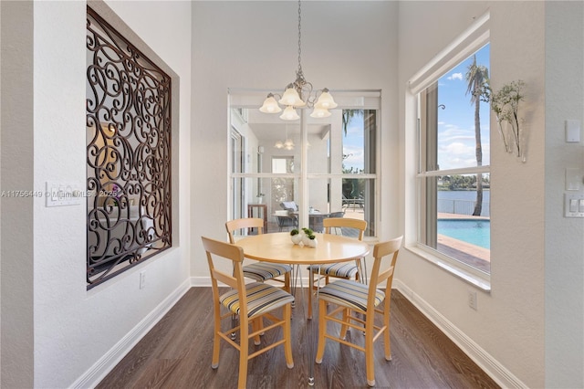 dining space with baseboards, dark wood-type flooring, and a chandelier