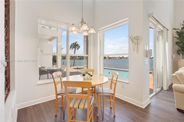 dining area featuring a chandelier, baseboards, and wood finished floors