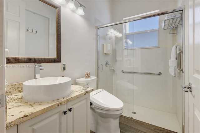 full bathroom with vanity, a shower stall, and toilet