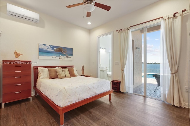 bedroom featuring dark wood-type flooring, recessed lighting, ensuite bath, a wall mounted AC, and access to outside