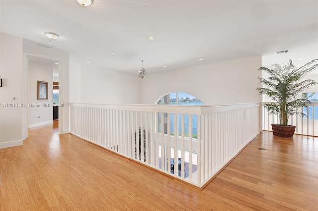 hallway featuring recessed lighting, visible vents, baseboards, and wood finished floors