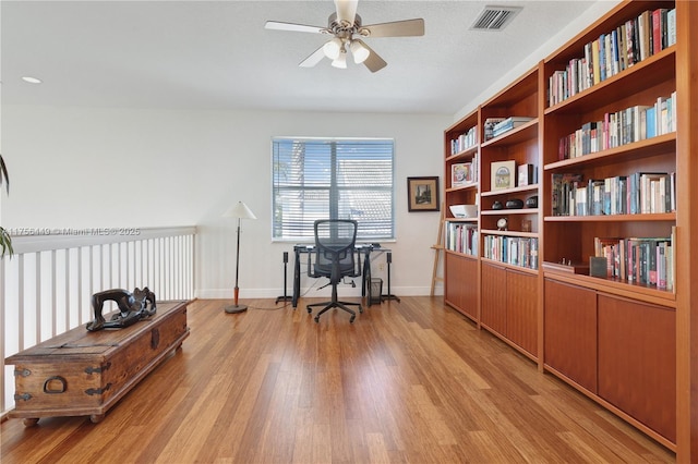 home office featuring ceiling fan, visible vents, baseboards, and light wood-style flooring