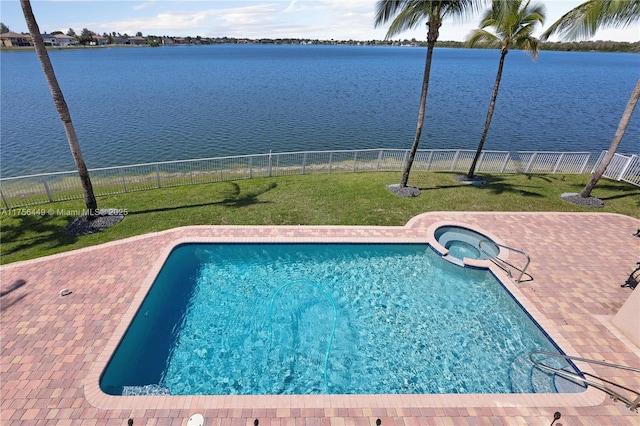 view of pool with a patio, fence, a yard, and a water view