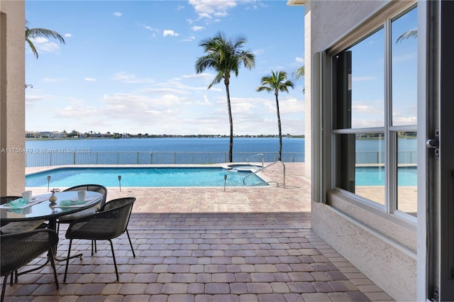 view of swimming pool with a fenced in pool, a water view, an in ground hot tub, and a patio area