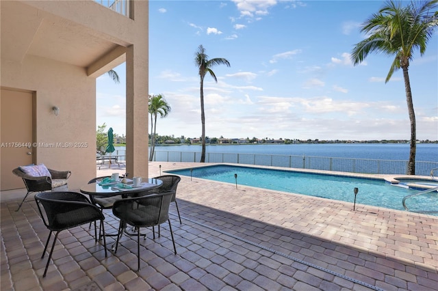 view of pool with a patio area, a pool with connected hot tub, and a water view