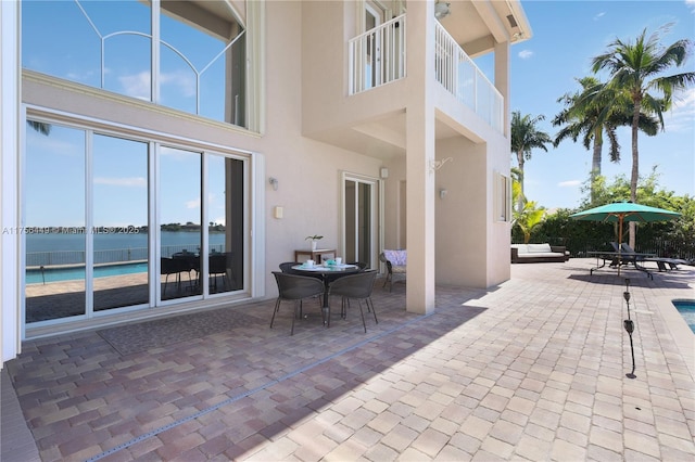 view of patio with a water view and outdoor dining space