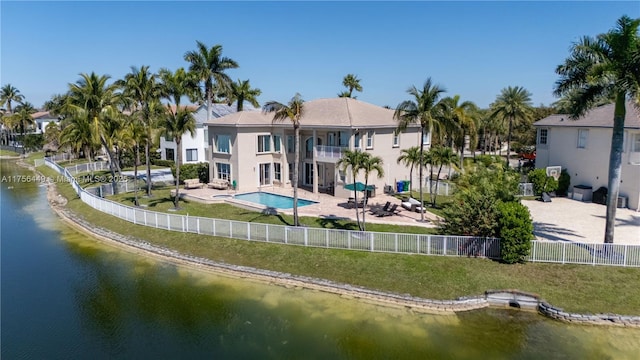 rear view of property featuring a fenced in pool, a water view, a fenced backyard, a balcony, and a patio