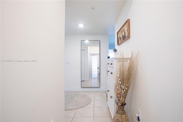 corridor with light tile patterned flooring and baseboards