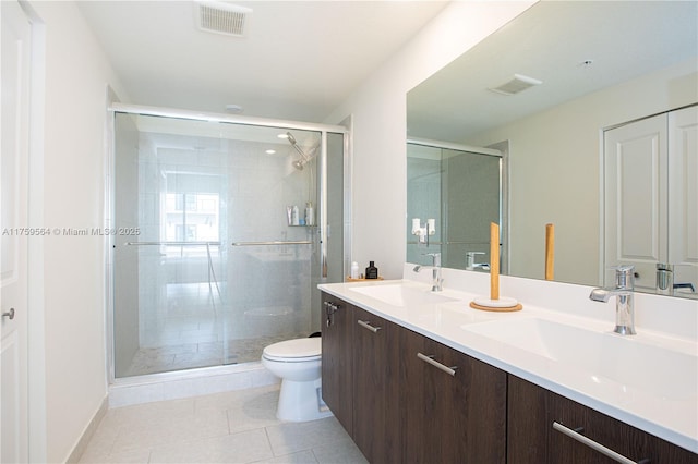 full bath with toilet, a shower stall, a sink, and tile patterned floors