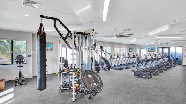 workout area with baseboards, visible vents, and ceiling fan