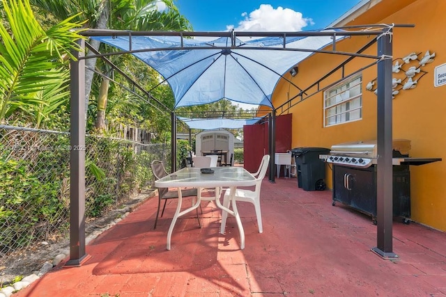 view of patio / terrace featuring an outbuilding, outdoor dining space, a storage shed, and fence