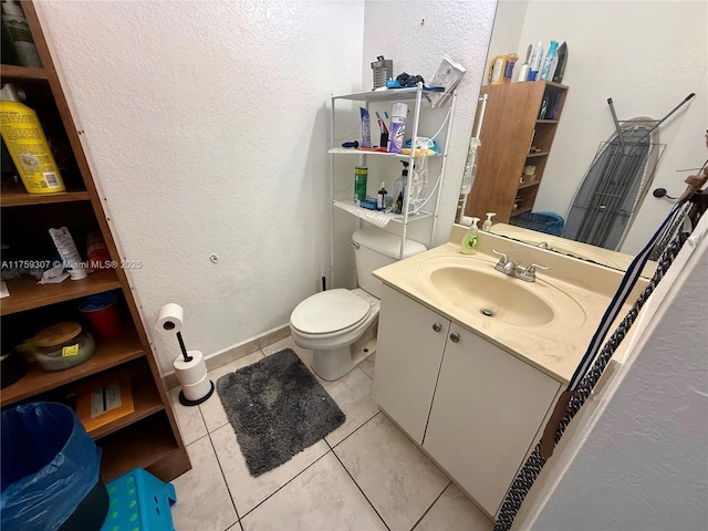 bathroom featuring a textured wall, vanity, toilet, and tile patterned floors