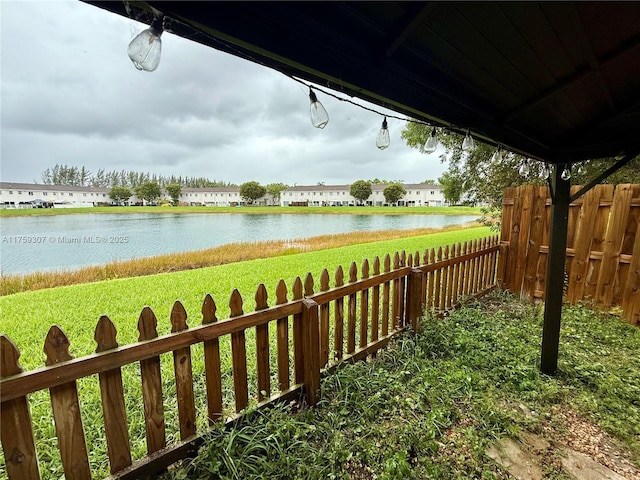 view of yard featuring a water view and fence