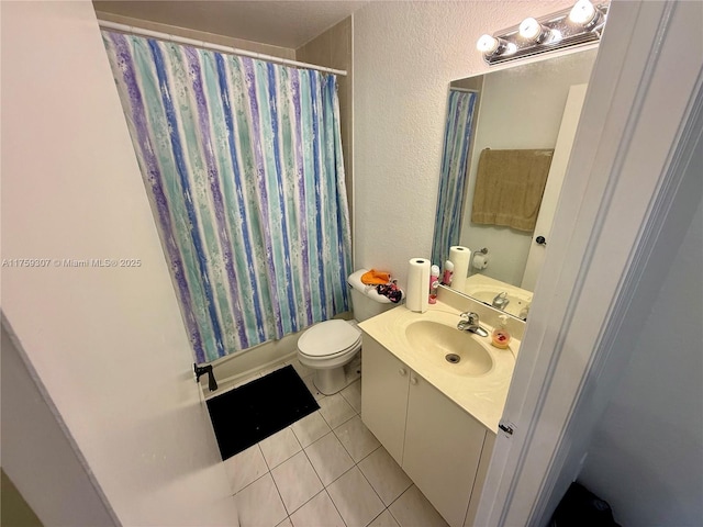 full bathroom featuring a textured wall, vanity, tile patterned flooring, and toilet