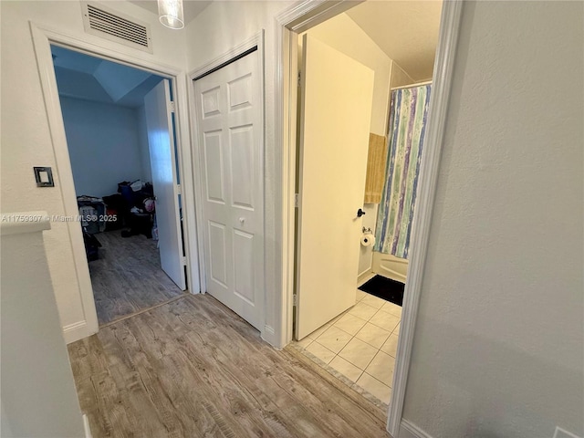 hall with visible vents and wood finished floors